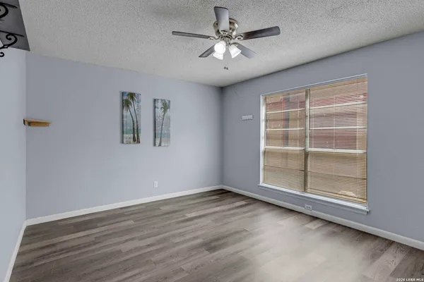 a view of an empty room with a window and wooden floor