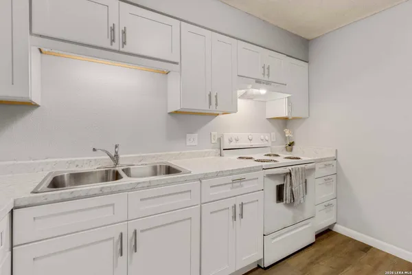 a kitchen with white cabinets and white appliances