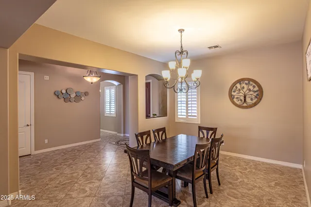 a dining room filled chandelier and kitchen view