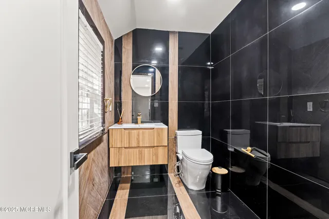 a bathroom with a toilet a sink and mirror