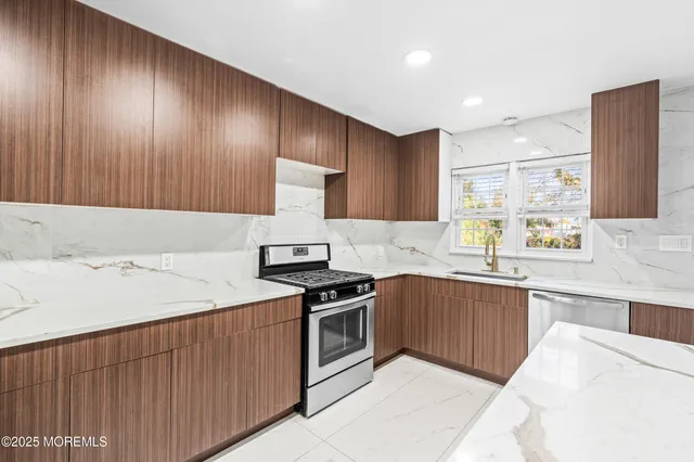 a kitchen with stainless steel appliances granite countertop a sink stove and refrigerator