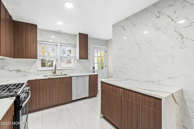 a kitchen with stainless steel appliances a sink dishwasher a stove a refrigerator and a oven