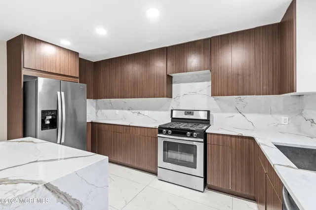 a kitchen with granite countertop stainless steel appliances and refrigerator
