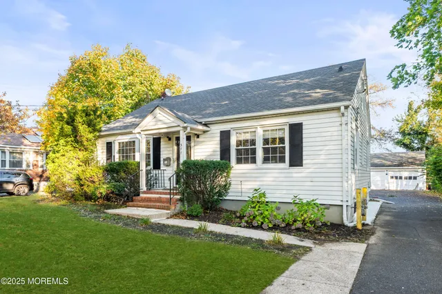 a front view of a house with a yard and potted plants