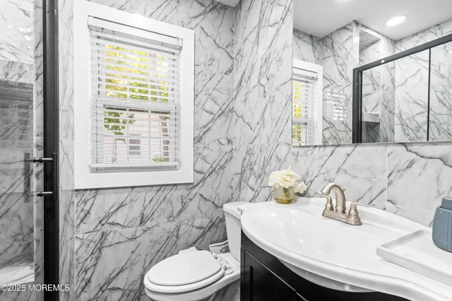 a bathroom with a sink a toilet and a window