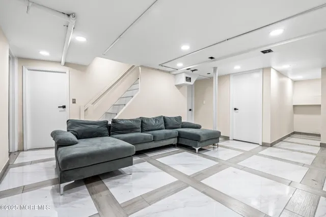 a living room with furniture and a glass door shower