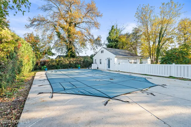 a view of a tennis ground with large trees
