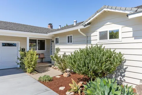 a front view of a house with plants