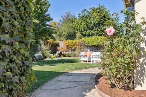 a view of a house with backyard and sitting area