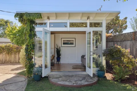 a porch area with table and chairs