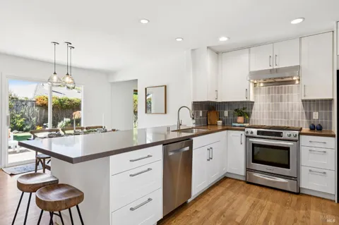 a kitchen with granite countertop a sink a stove and cabinets