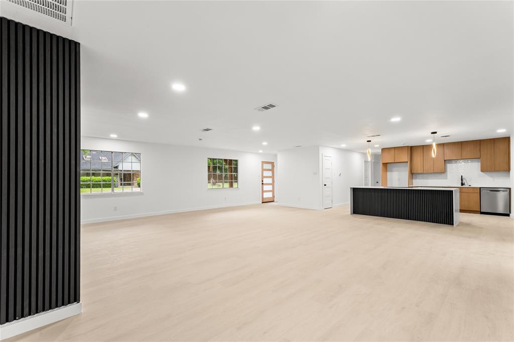 110 Hackberry Street Lancaster, TX 75146 - Photo 5 of 32 Spacious open-concept living area featuring light wood-finish flooring, recessed lighting, and a prominent black slatted accent wall