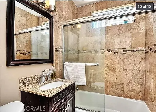 a bathroom with a granite countertop sink a mirror and a bathtub