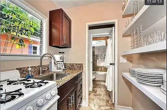 a kitchen with a sink stove top oven and cabinets
