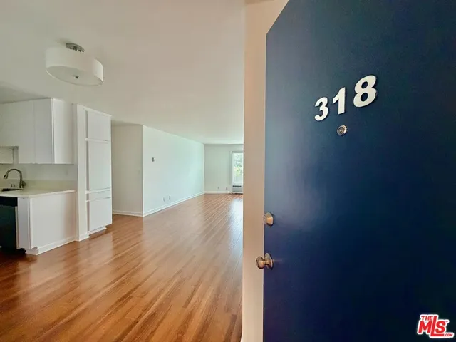 a view of a kitchen with wooden floor and a large window