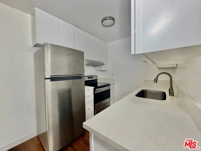 a kitchen with wooden floor and a stove top oven