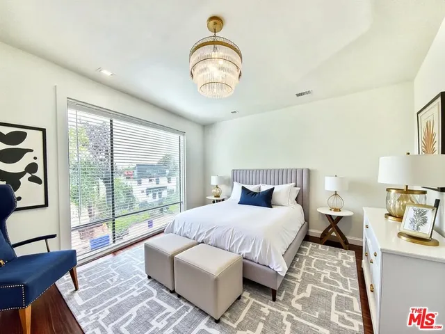 a bedroom with bed and a large window