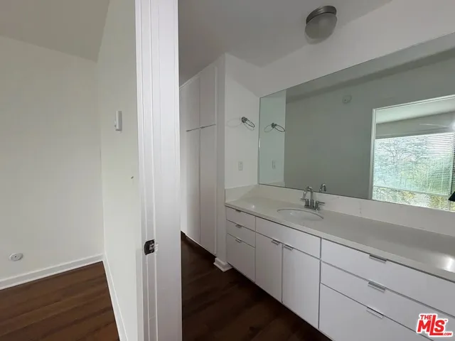 a en suite bathroom with a granite countertop sink and a mirror