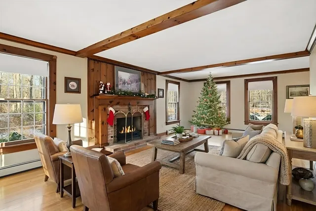 a living room with fireplace furniture and a large window