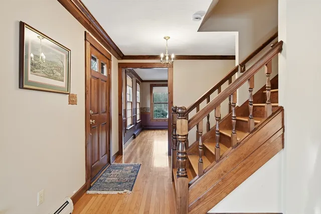 a view of a hallway with wooden floor and stairs