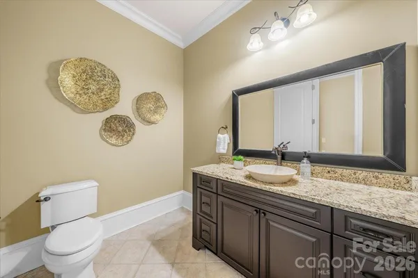 a bathroom with a granite countertop sink mirror vanity and toilet