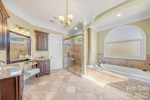 a spacious bathroom with a double vanity sink a large mirror and a bathtub