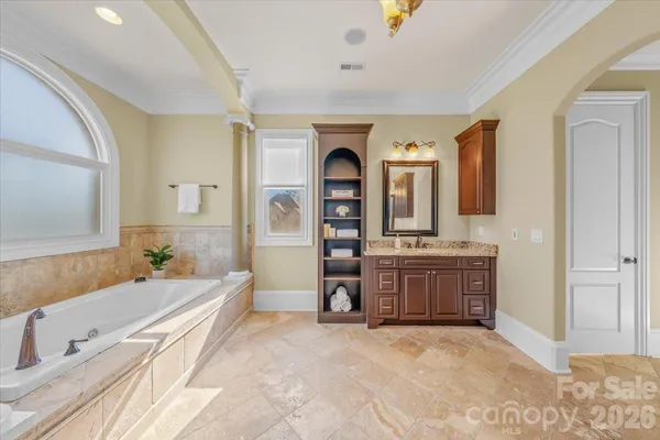 a spacious bathroom with a tub sink and mirror