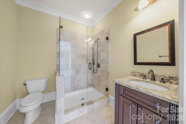 a bathroom with a granite countertop sink a toilet and shower