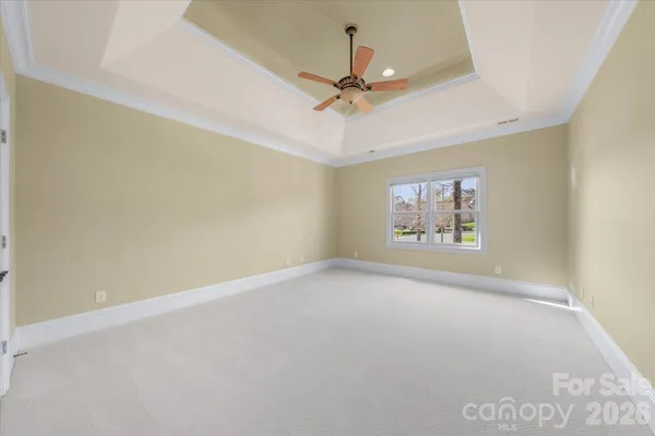 an empty room with a ceiling fan and window