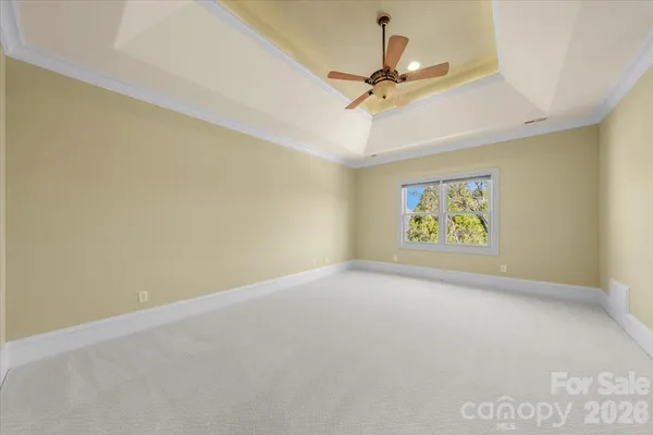 an empty room with a ceiling fan and window