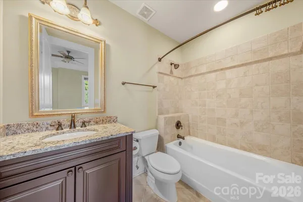 a bathroom with a granite countertop sink a toilet and bathtub