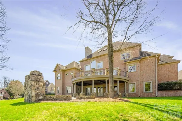 a front view of a house with a yard fountain and large tree