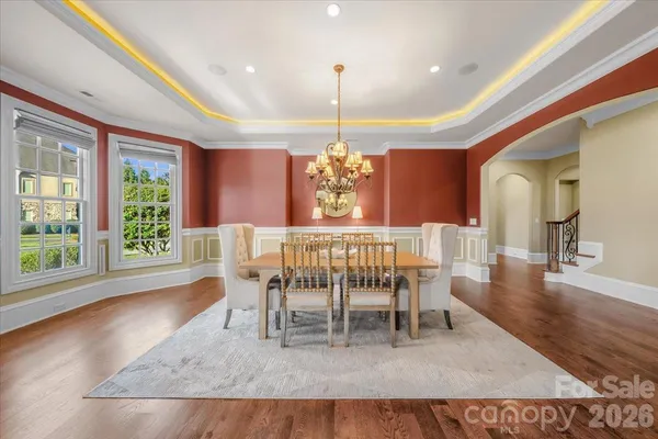 a dining room with furniture a chandelier and wooden floor