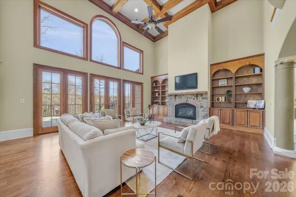 a living room with furniture a fireplace and a floor to ceiling window