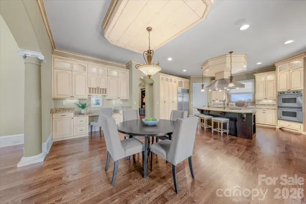 a kitchen with stainless steel appliances kitchen island granite countertop a table chairs and a refrigerator