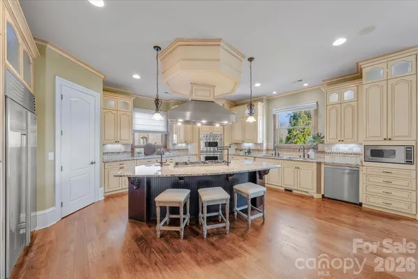 a kitchen with a dining table chairs wooden floor and appliances