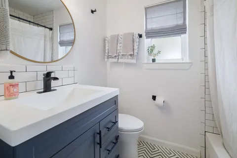 a bathroom with a sink a toilet and a mirror