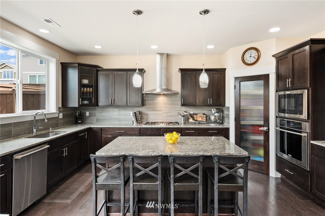 4113 172nd Place Southeast Bothell, WA 98012 - Photo 32 of 32 a kitchen with stainless steel appliances granite countertop a sink a stove a refrigerator cabinets and dining table
