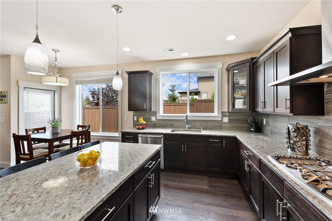 4113 172nd Place Southeast Bothell, WA 98012 - Photo 6 of 32 a large kitchen with kitchen island granite countertop a sink and a stove