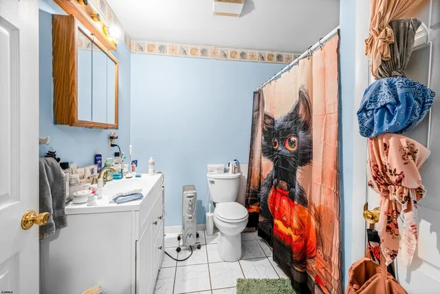 a bathroom with a sink toilet and shower curtain