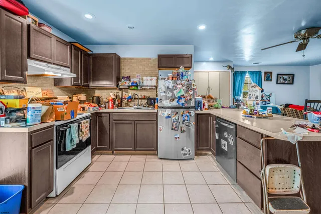 a kitchen with a sink a stove top oven and cabinets