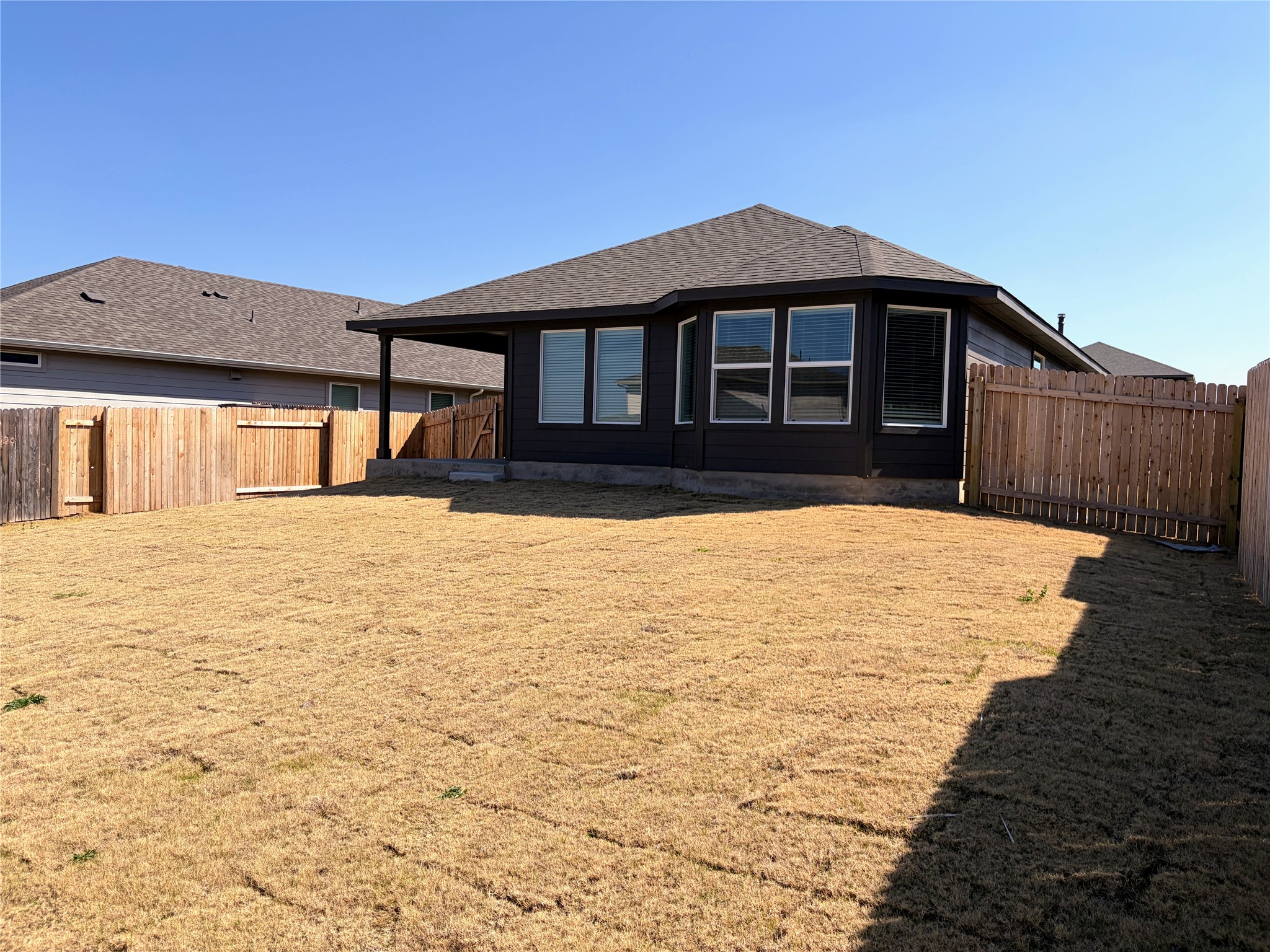 440 El Capitan Loop Dripping Springs, TX 78620 - Photo 18 of 22 Back of property featuring a shingled roof and a fenced backyard
