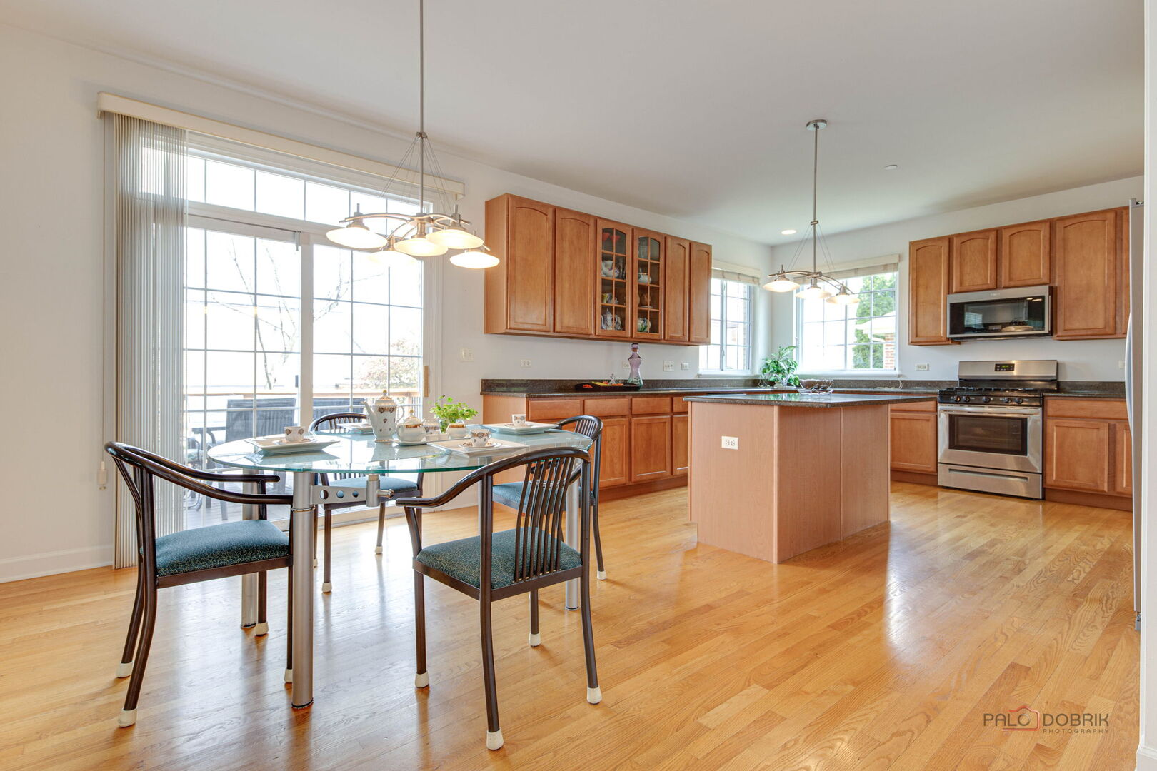 1330 Horizon Trail Wheeling, IL 60090 - Photo 13 of 39 a kitchen with stainless steel appliances granite countertop wooden floor dining table and chairs