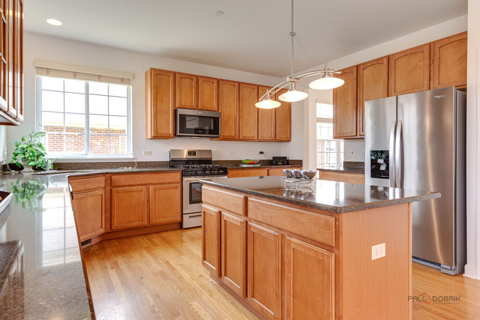 1330 Horizon Trail Wheeling, IL 60090 - Photo 17 of 39 a kitchen with stainless steel appliances granite countertop a refrigerator a sink dishwasher a stove and a dining table with wooden floor