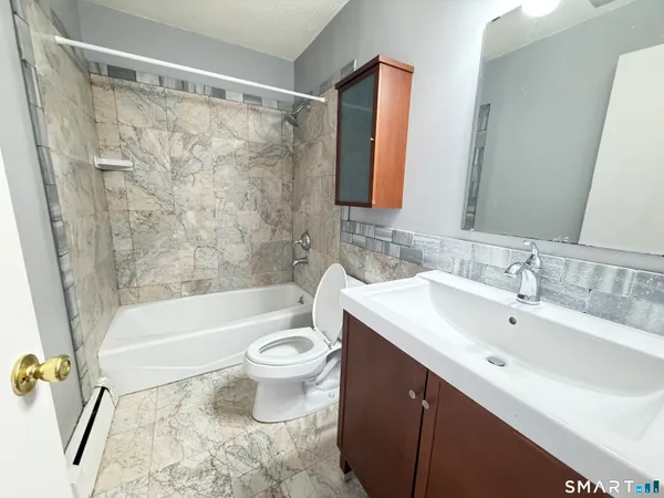 a bathroom with a sink a toilet and bathtub
