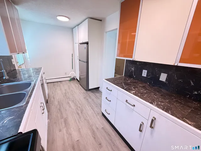 a kitchen with sink cabinets and wooden floor