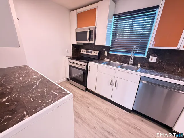 a kitchen with granite countertop a stove and a sink