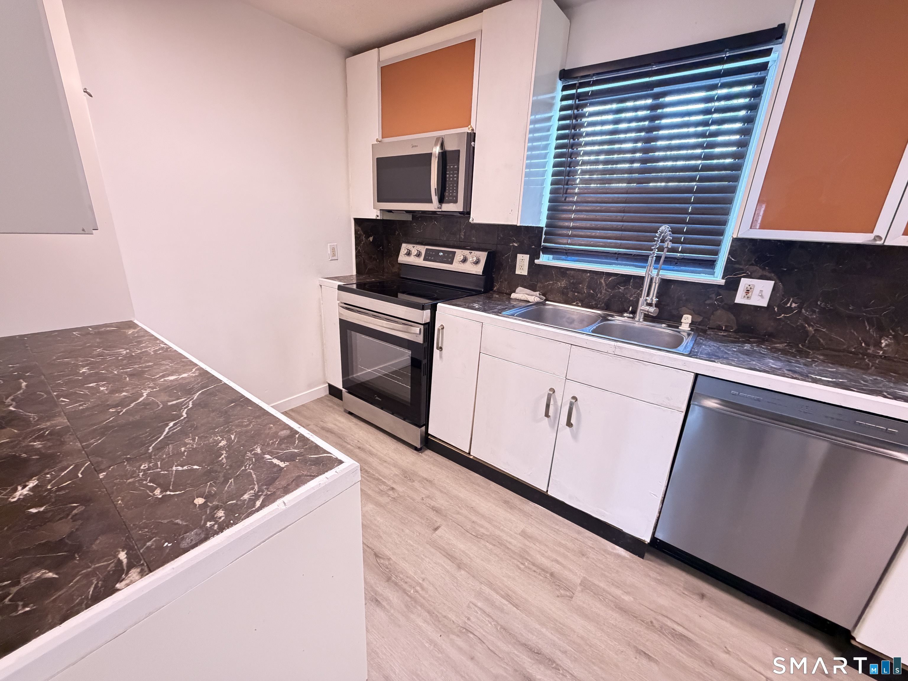 148 High Path Road, Unit 148 Windsor, CT 06095 - Photo 5 of 14 a kitchen with granite countertop a stove and a sink