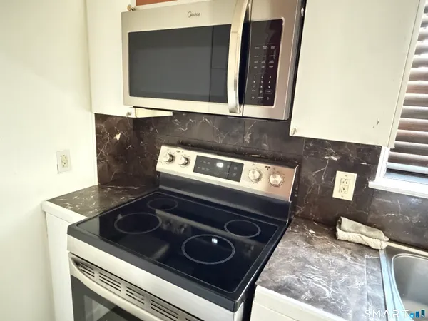 a stove top oven sitting inside of a kitchen