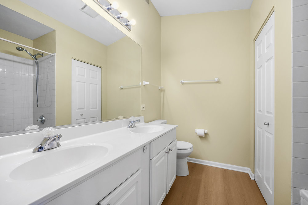 2277 Reflections Drive, Unit 2277 Aurora, IL 60502 - Photo 12 of 15 a bathroom with a sink a toilet a shower and a mirror